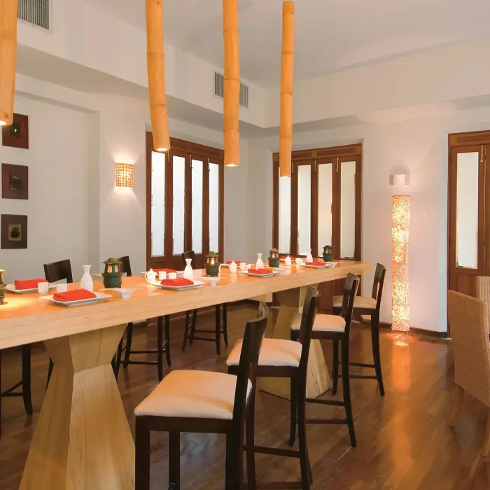Contemporary sushi bar with minimalist wooden decor and hanging bamboo lights.