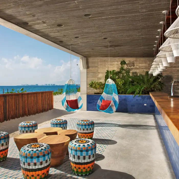 Beachfront Barracuda Bar with colorful stools, swings, and relaxed tropical vibes steps from the sand.