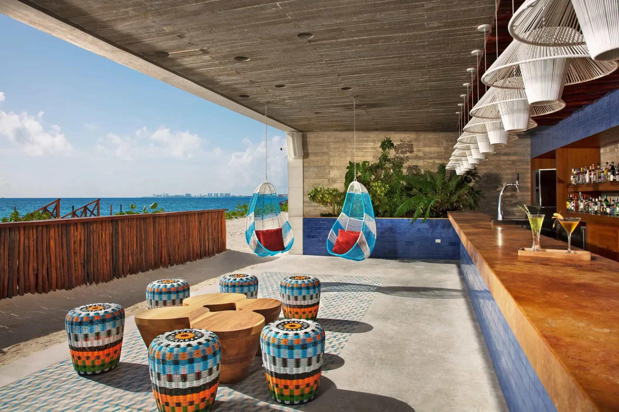 Beachfront Barracuda Bar with colorful stools, swings, and relaxed tropical vibes steps from the sand.