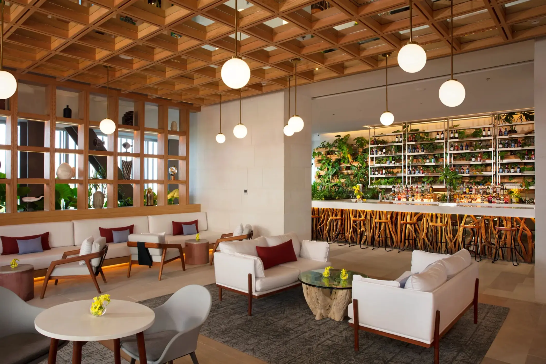 Stylish Rendezvous lobby bar featuring lush decor, natural wood accents, and indoor garden elements.