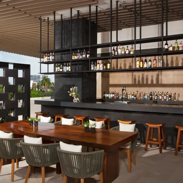 Chic Veranda Bar with open-air seating, dark wood bar, and elegant contemporary design.