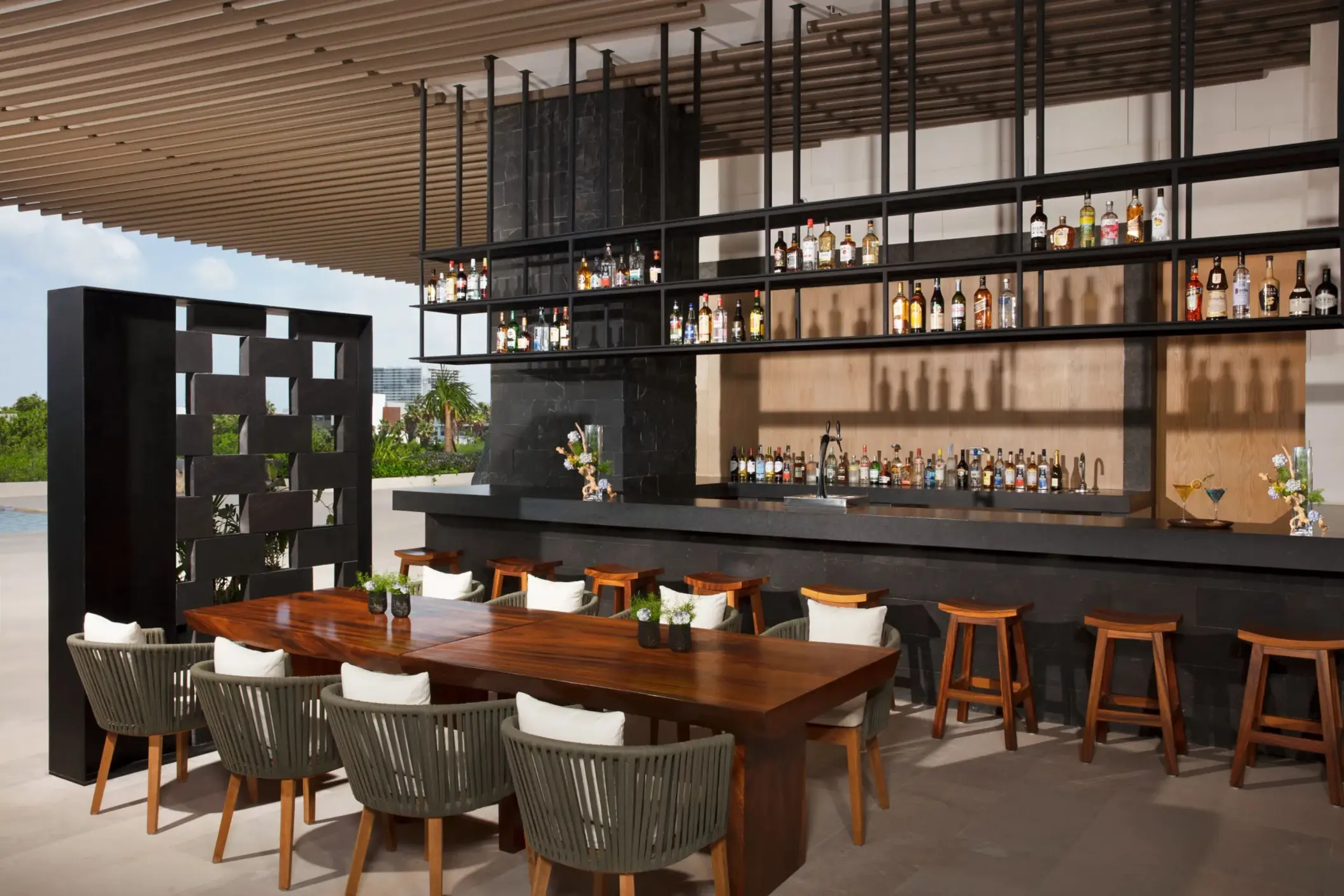 Chic Veranda Bar with open-air seating, dark wood bar, and elegant contemporary design.