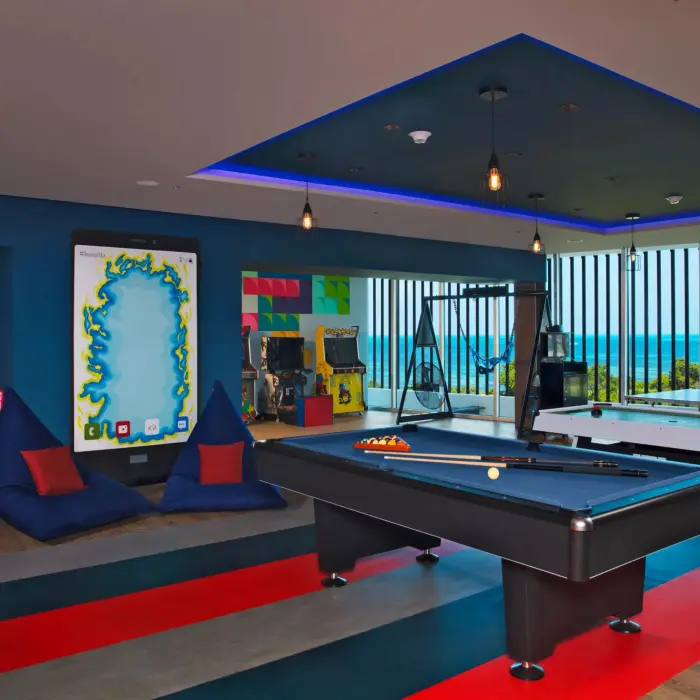 Modern teen lounge with bean bags, game tables, and ocean views at the Core Zone.