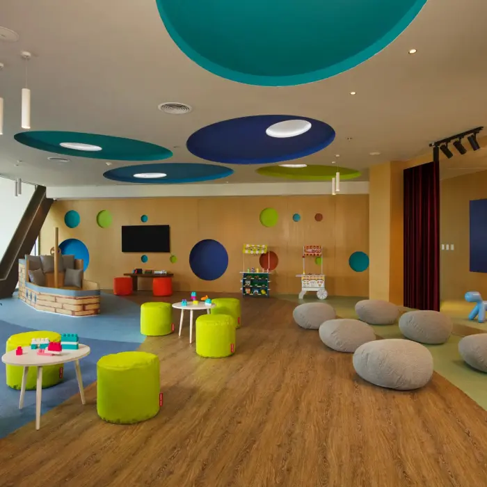 Colorful Explorer’s Club indoor play area with games, soft seating, and telescopes for kids.