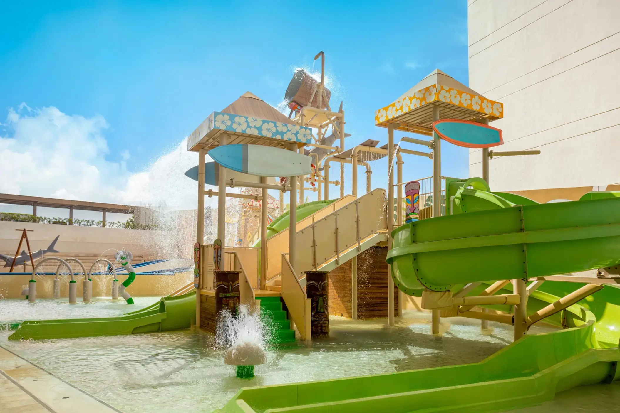 Surf simulator with instructor helping young guest ride the waves under vibrant mural walls.