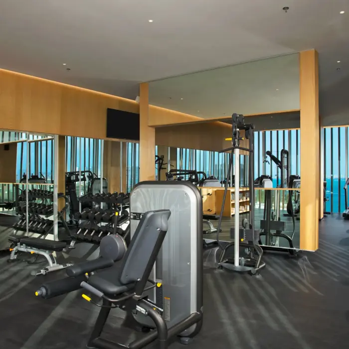 Modern fitness center at Dreams Vista Cancun featuring cardio and strength equipment with sea views.