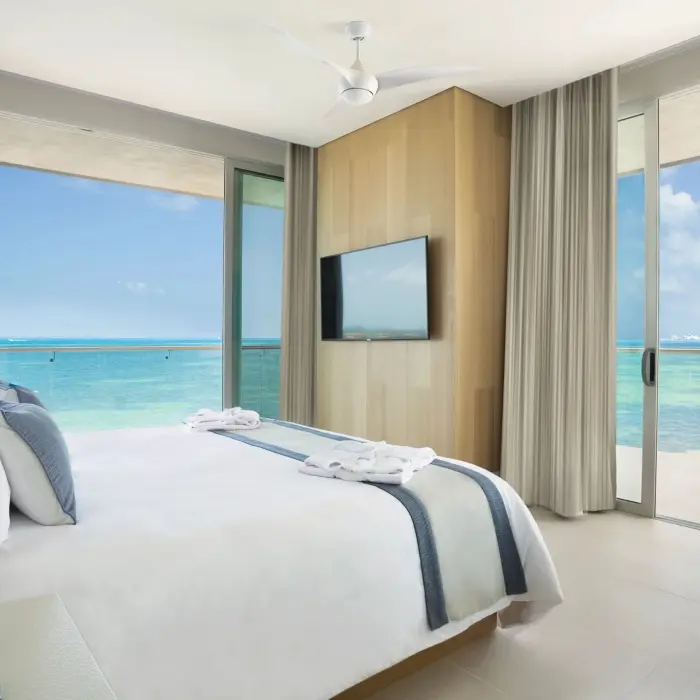 Master one-bedroom suite with king bed and floor-to-ceiling ocean view windows at Dreams Vista Cancun.