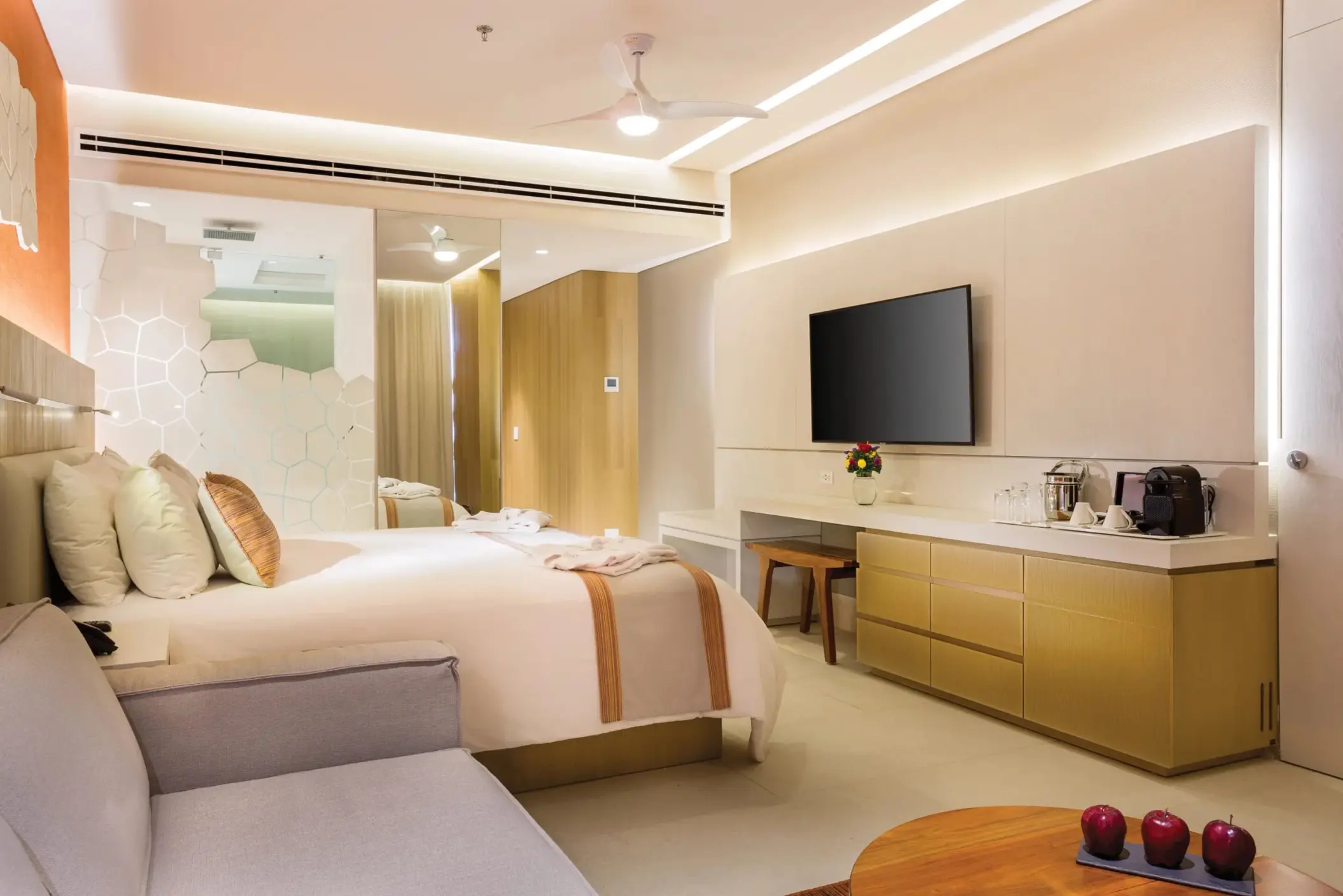 Deluxe ocean view room with king bed, sleek furnishings, and balcony seating overlooking crystal-clear waters.