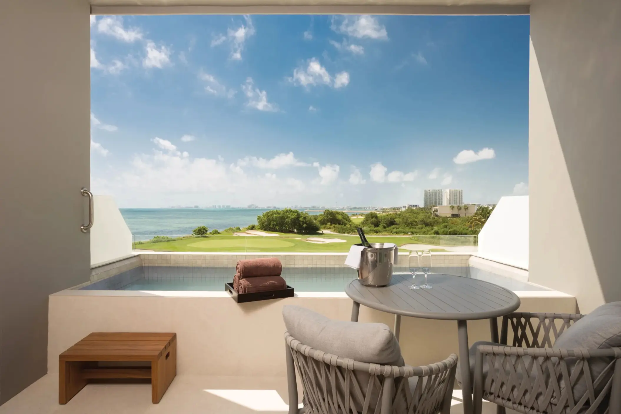 Balcony setup with two chairs and ocean view, offering a serene and private outdoor escape for two guests.