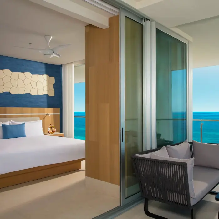 Oceanfront master suite with king bed and cozy sitting area on the balcony offering sweeping sea views.