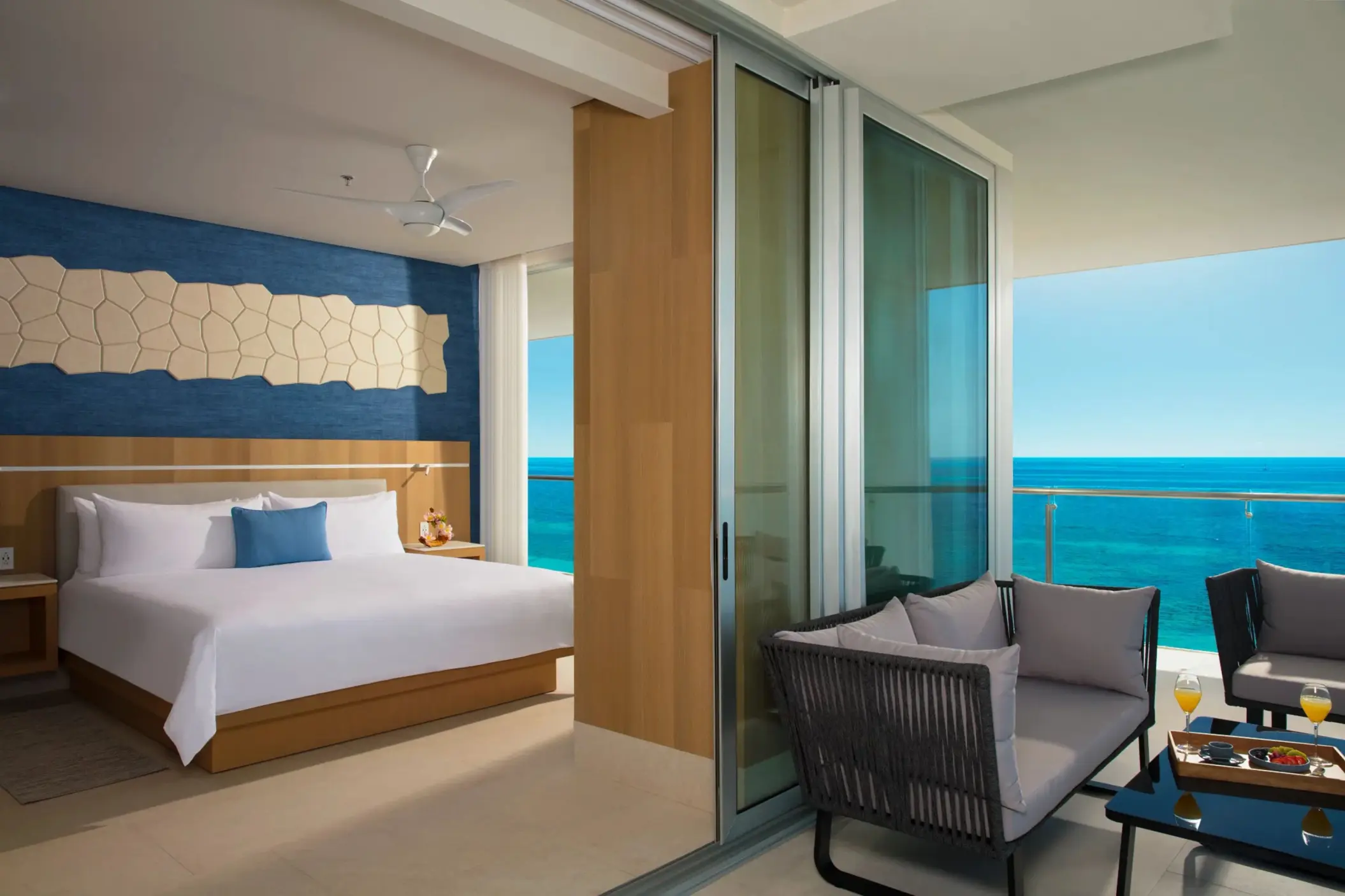 Oceanfront master suite with king bed and cozy sitting area on the balcony offering sweeping sea views.