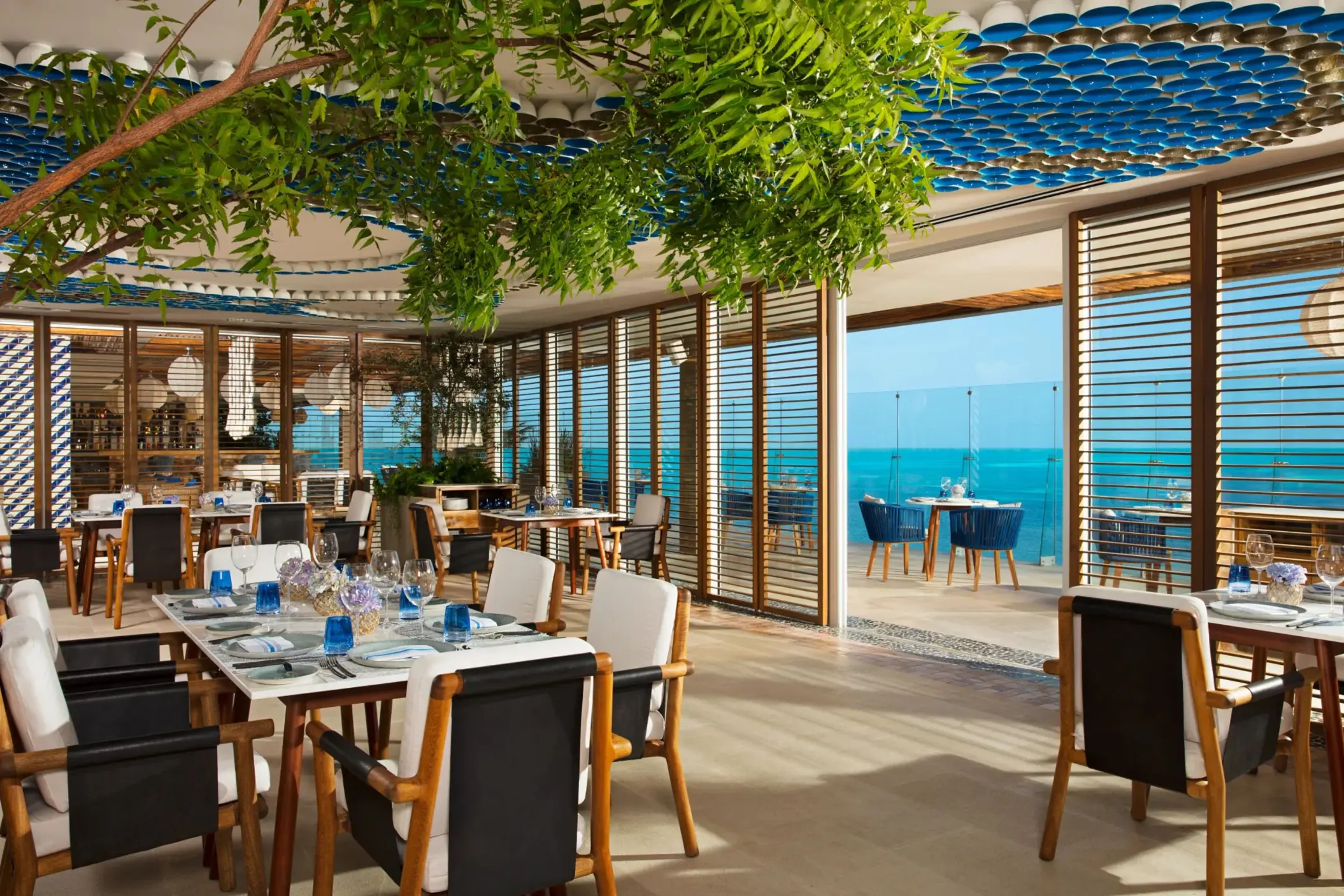 Bright seaside dining at Blue Water Grill with blue decor, natural lighting, and ocean views.