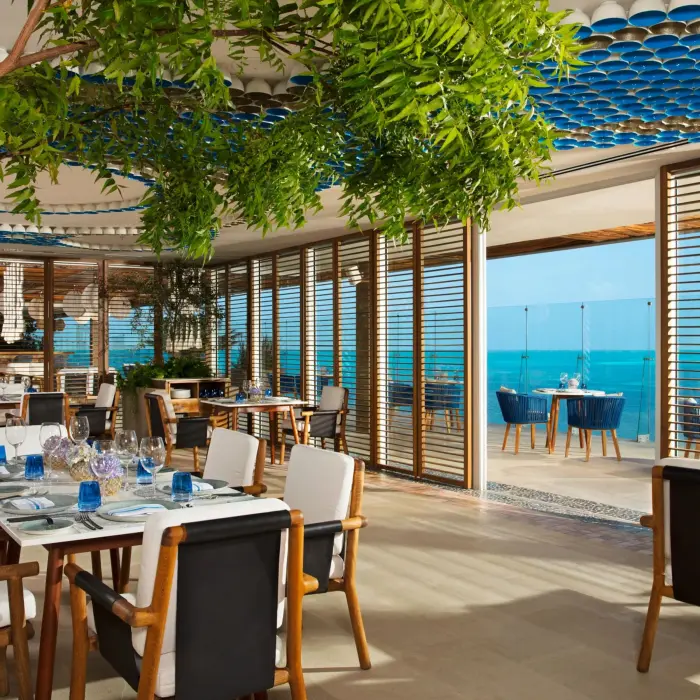 Bright seaside dining at Blue Water Grill with blue decor, natural lighting, and ocean views.