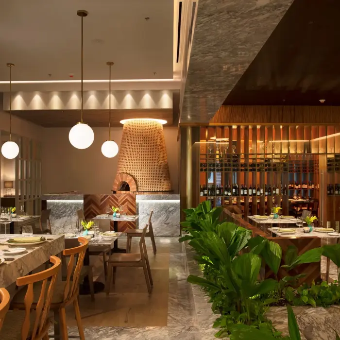 Elegant Italian dining at Portofino with marble accents, wine display, and soft lighting.