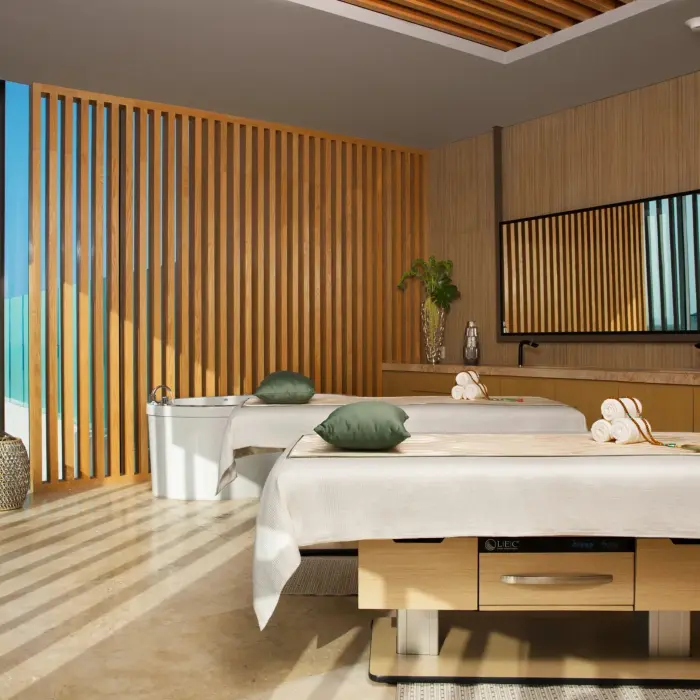 Oceanview couples’ massage room with treatment beds and wooden decor.