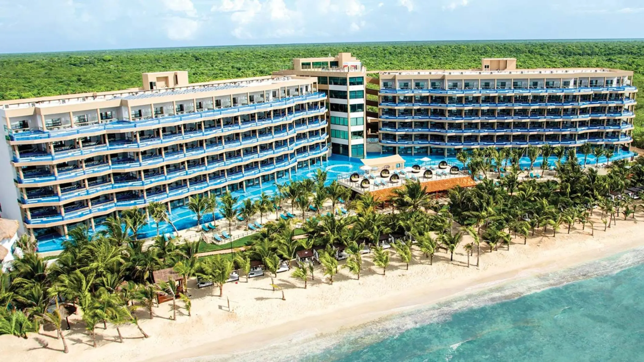exterior view of El Dorado Seaside Suites with its buildings and pools and beach