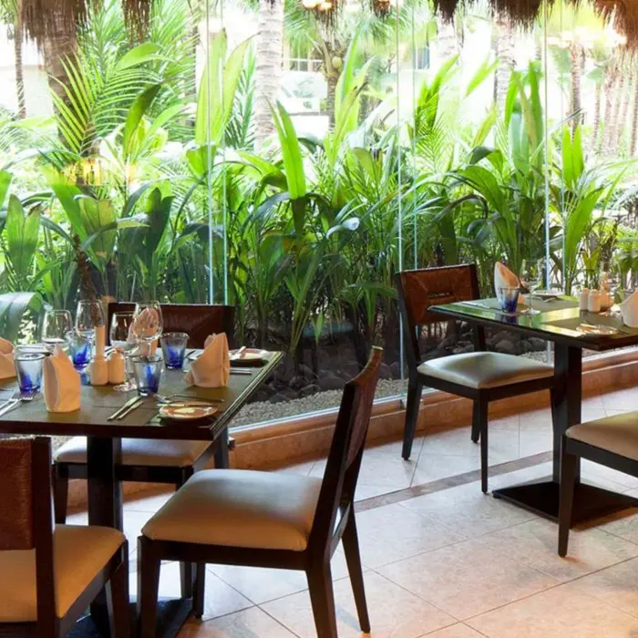 restaurant with lush garden views at El Dorado Seaside Suites