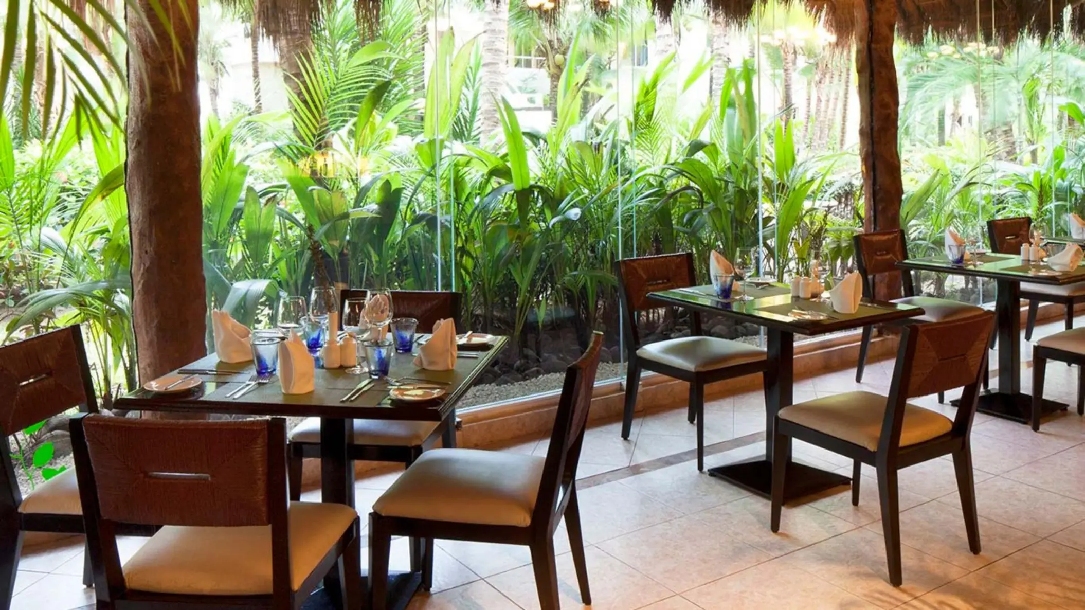 restaurant with lush garden views at El Dorado Seaside Suites
