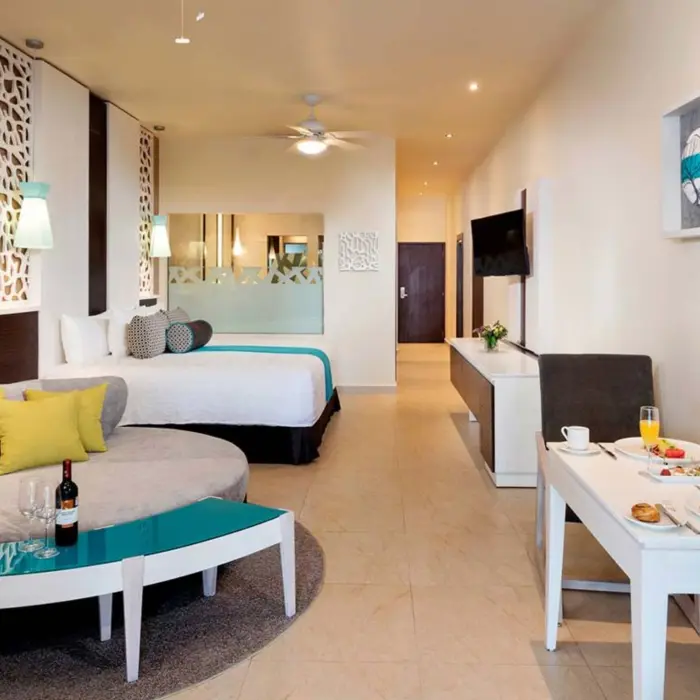 suite with king bed and blue and brown decor at El Dorado Seaside Suites