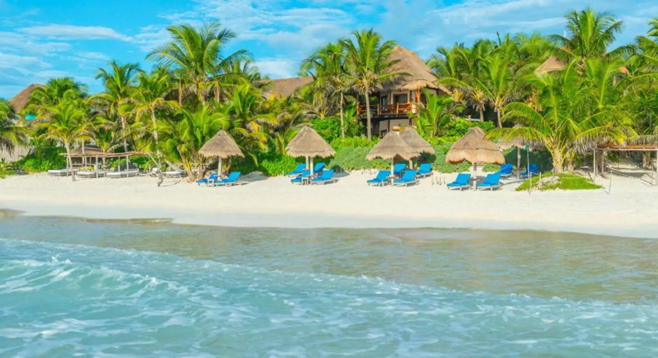 beach and loungers and resort buildings at Encantada Tulum