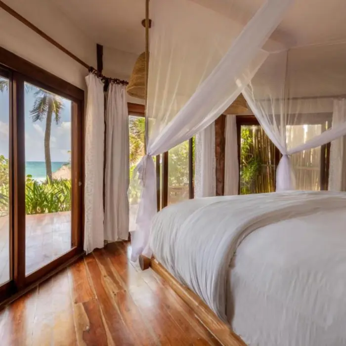beach front lower room with bed and wooden flooring at Encantada Tulum