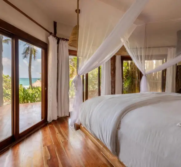 beach front lower room with bed and wooden flooring at Encantada Tulum