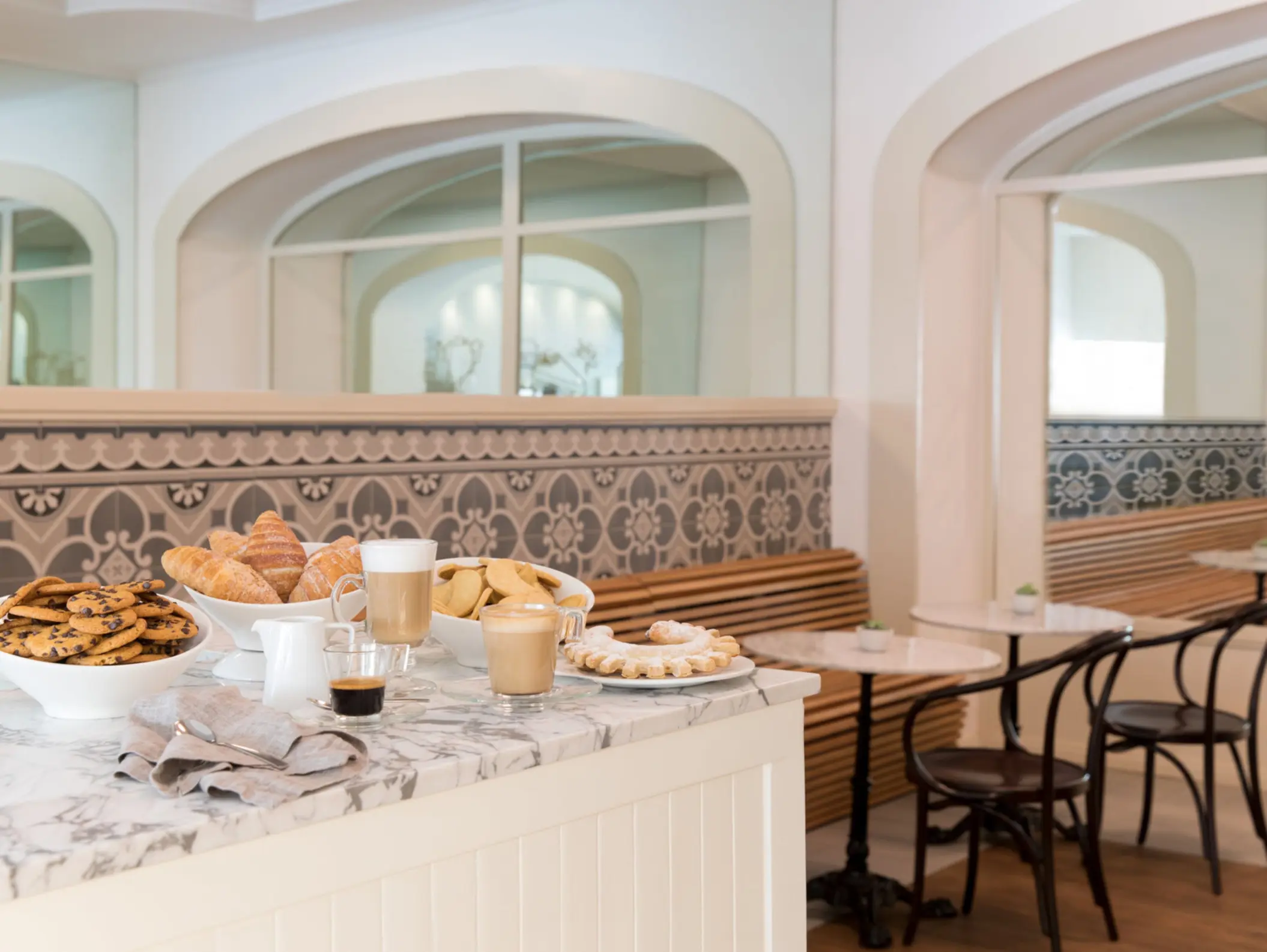 Charming café with marble countertops, pastries, and fresh coffee inside a boutique resort setting.