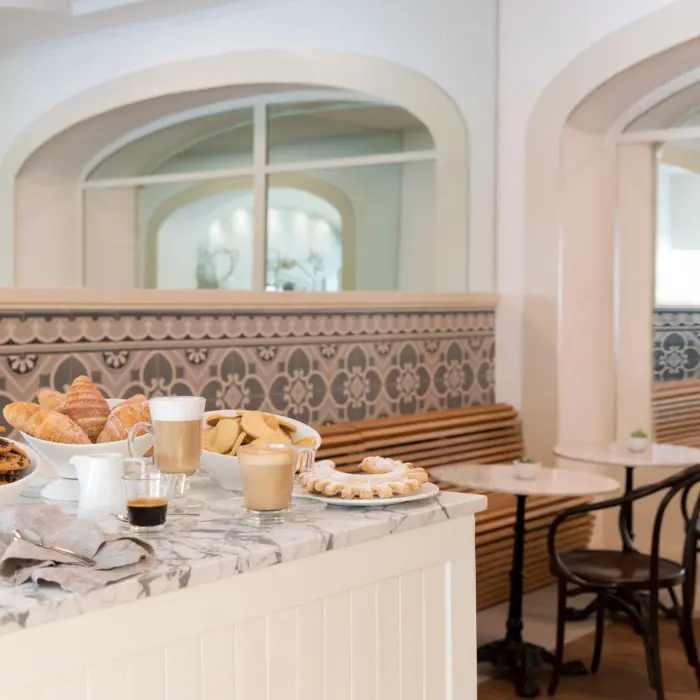 Charming café with marble countertops, pastries, and fresh coffee inside a boutique resort setting.