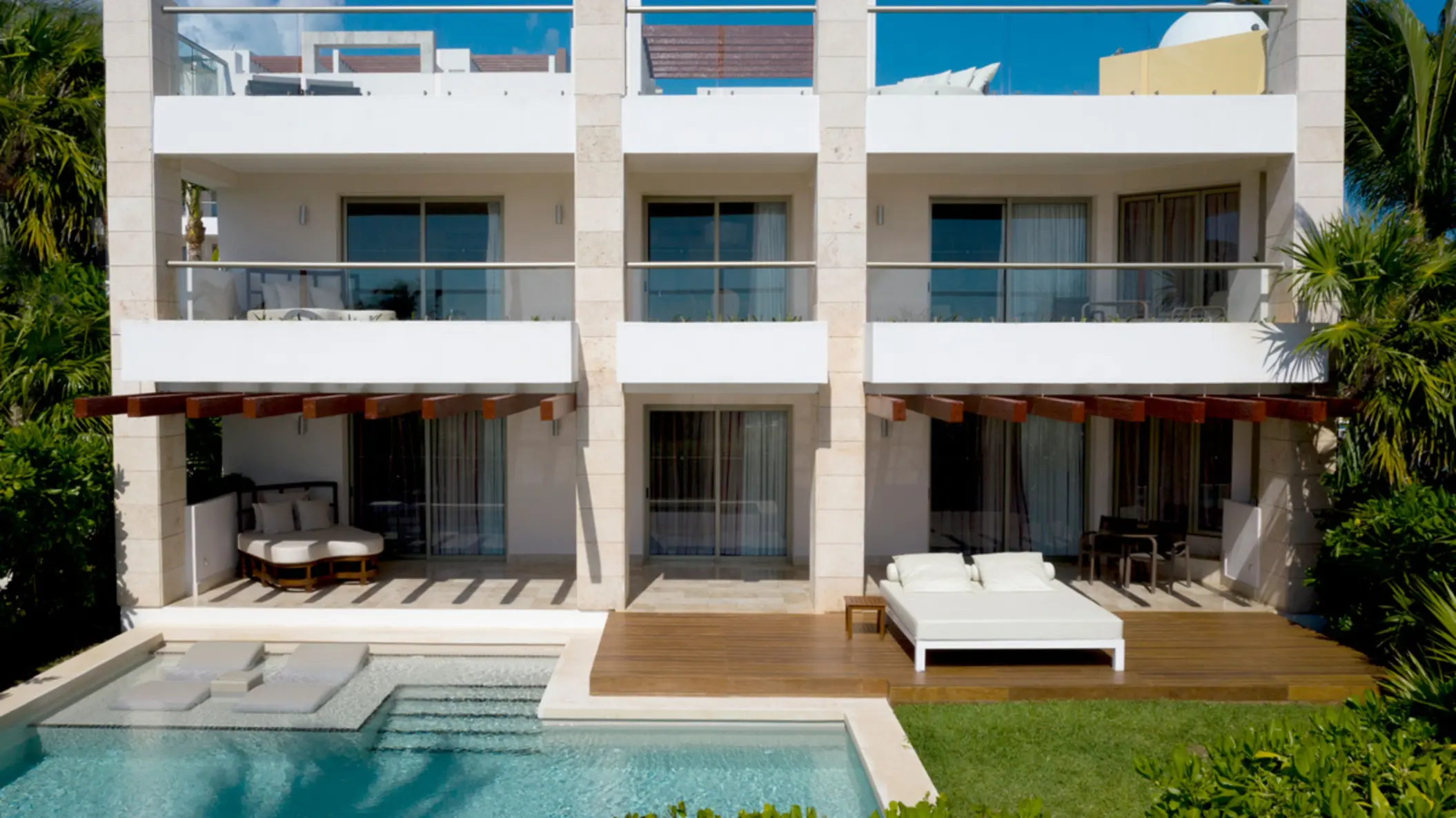 Swim-up suites with private patios, cushioned loungers, and direct pool access at a luxury Cancun resort.