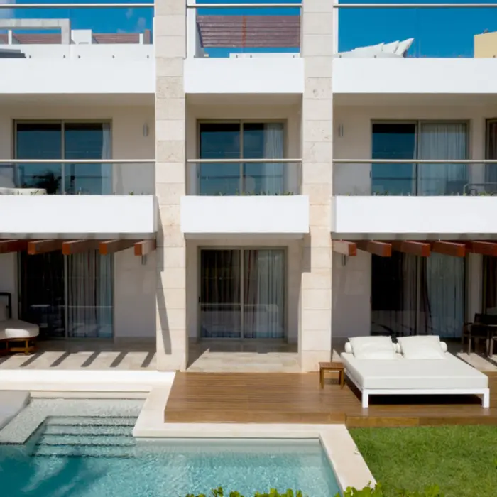 Swim-up suites with private patios, cushioned loungers, and direct pool access at a luxury Cancun resort.