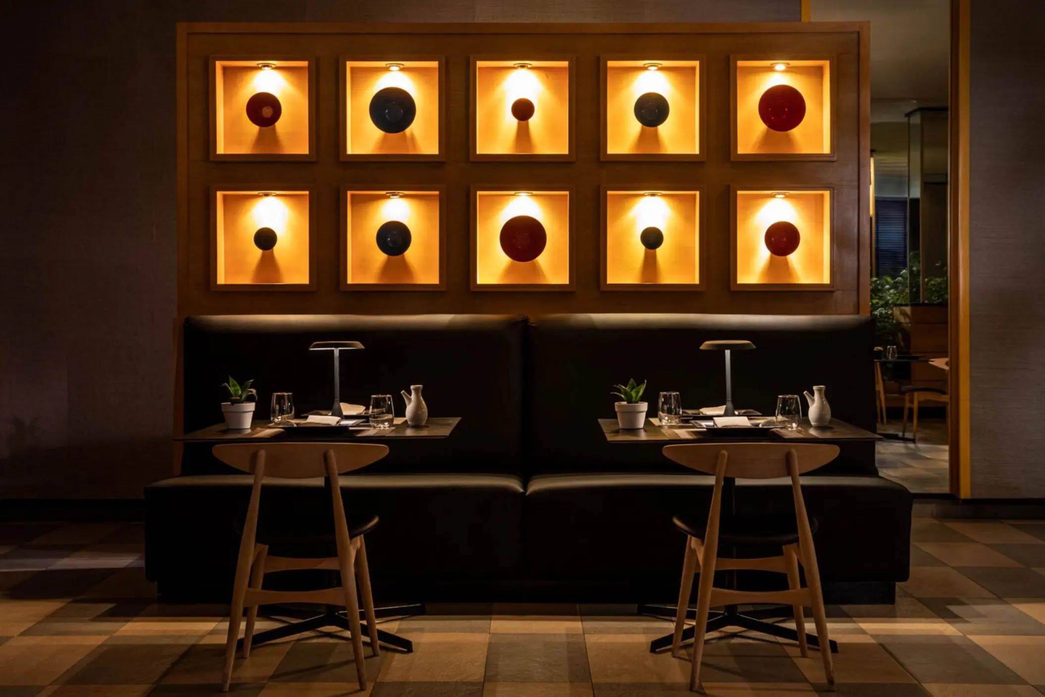 Elegant Asian restaurant interior with warm lighting, minimalist decor, and illuminated art wall display.