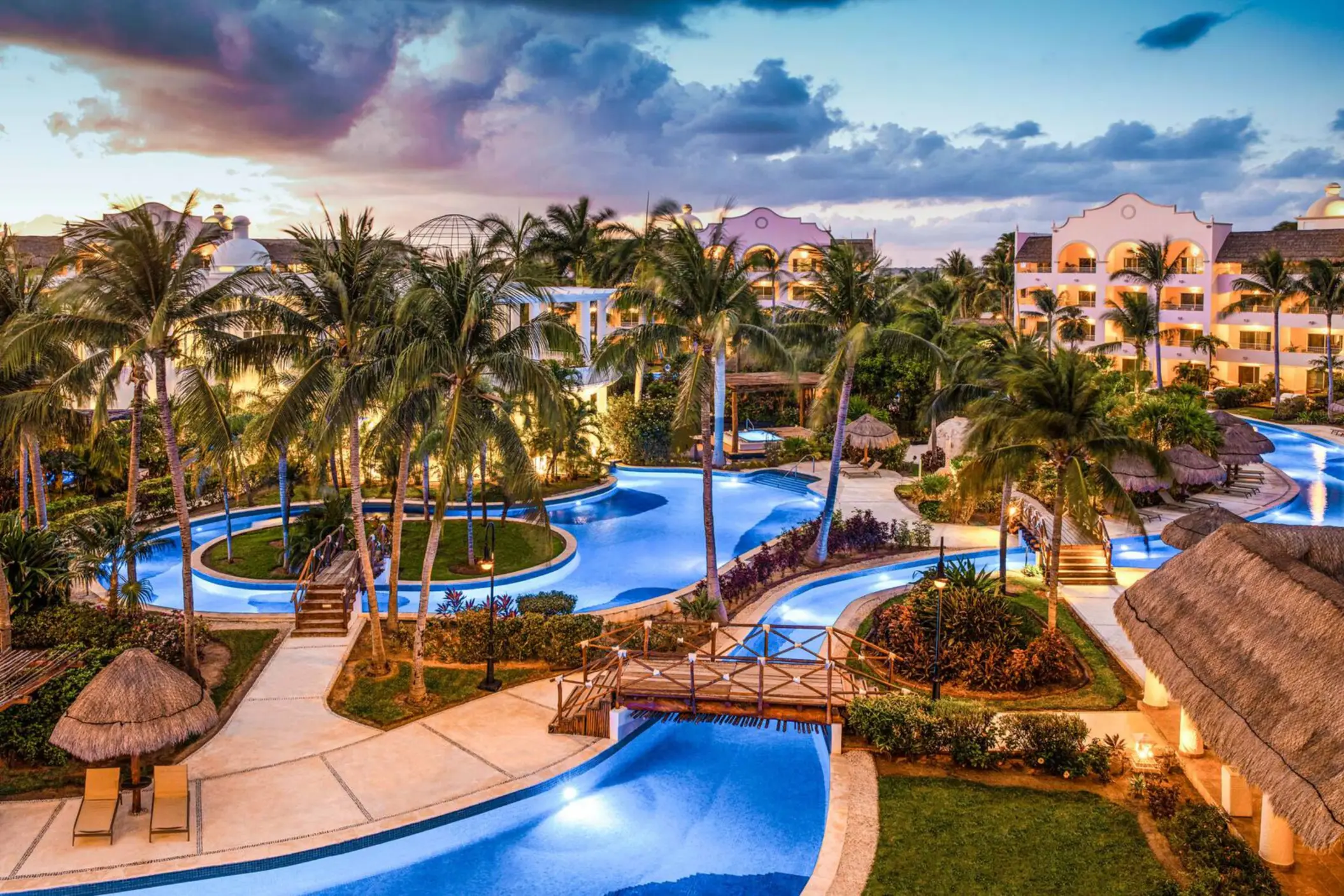 Resort domes and architecture glowing at dusk under a soft pink and lavender sky during a peaceful sunset.