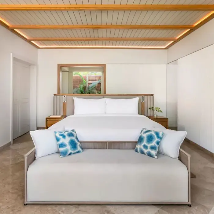 comfortable double bed inside a suite at Fairmont Mayakoba