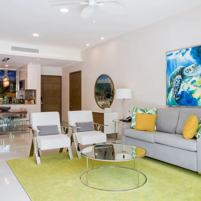 Bright open-concept living area with colorful decor, modern furnishings, and kitchen and dining area in view.