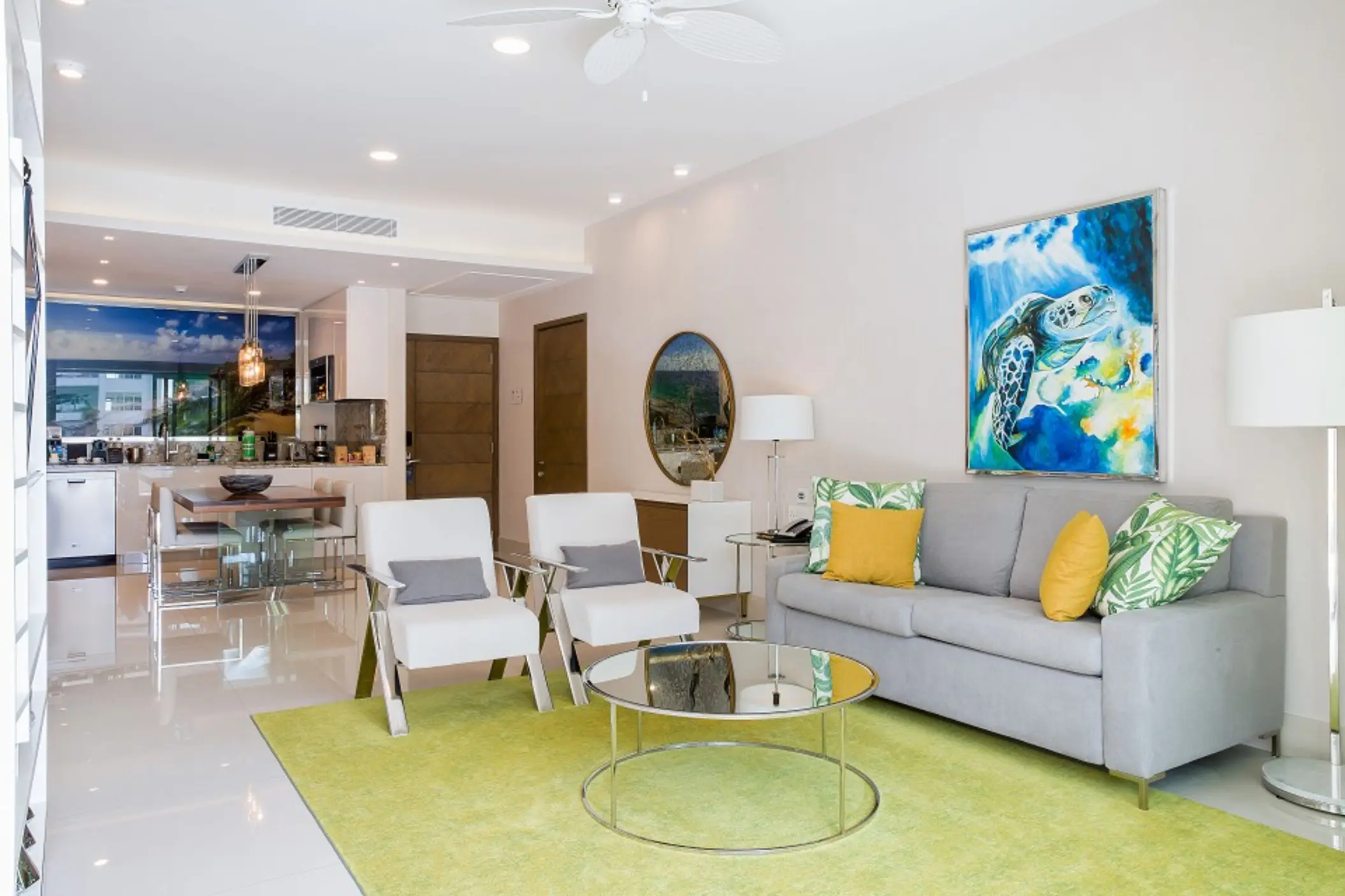 Bright open-concept living area with colorful decor, modern furnishings, and kitchen and dining area in view.