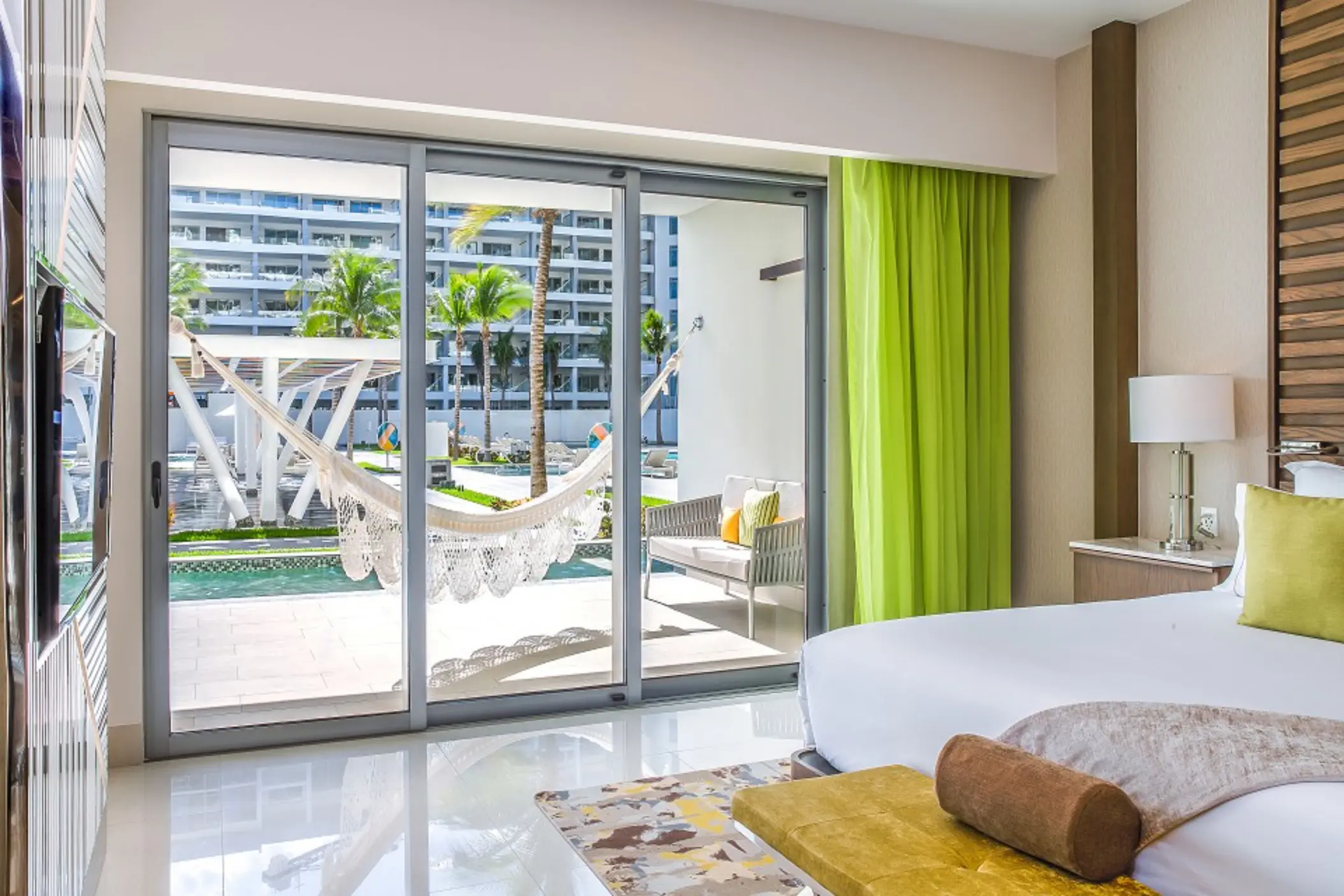 Swim-up Junior Suite with king bed, indoor seating, and terrace that opens directly into the pool.