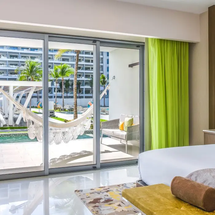 Swim-up Junior Suite with king bed, indoor seating, and terrace that opens directly into the pool.