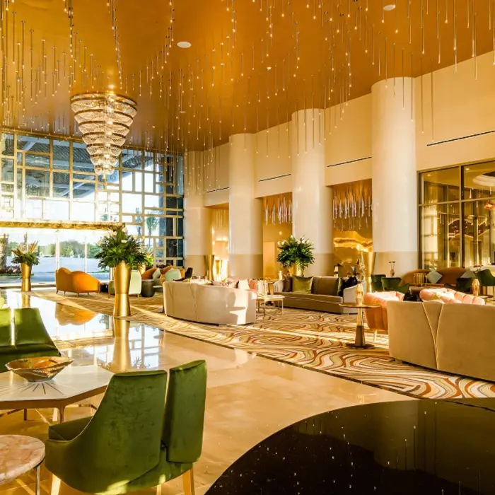 Spacious resort lobby with curved wooden ceiling design, plush seating, and warm ambient lighting.