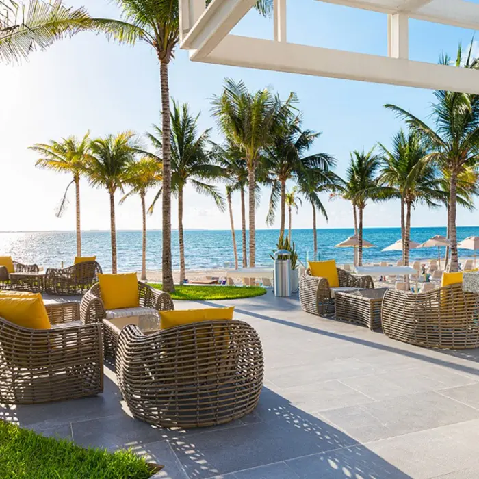 Palm-lined pool deck with ocean views, sunbeds, and shaded lounge areas at Garza Blanca Cancun.