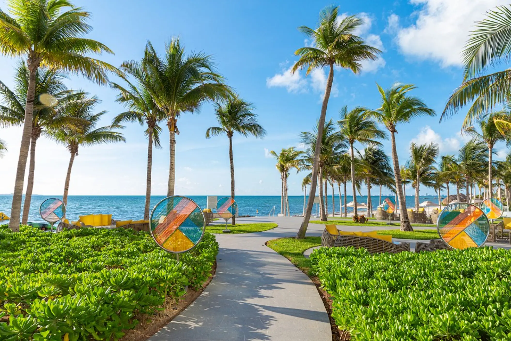 Resort pool with stone steps, tropical landscaping, and views of the Caribbean Sea in the background.