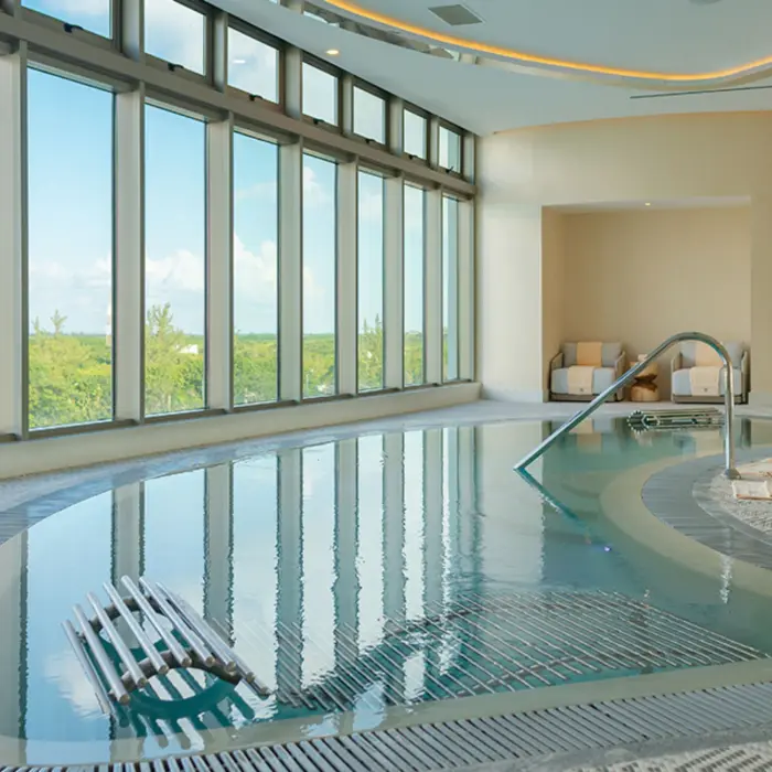Spacious spa cabin with soft lighting, massage beds, and wall art creating a serene and calming atmosphere.