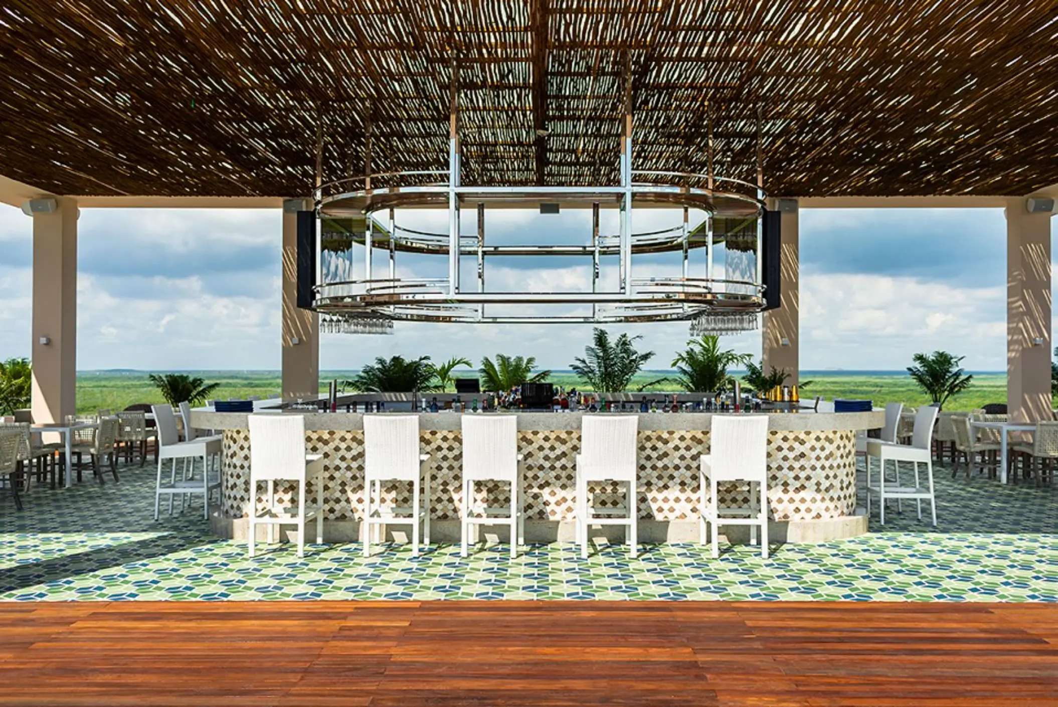 Chic rooftop bar with modern seating, open-air layout, and panoramic sunset views over the Caribbean Sea.