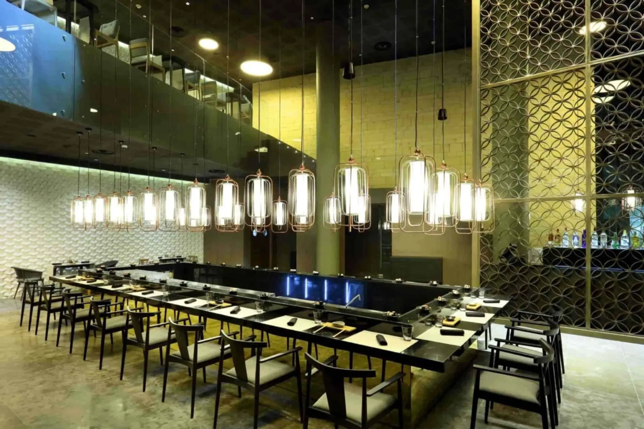 Elegant sushi restaurant with sleek decor, modern lighting, and spacious bar seating for interactive dining.