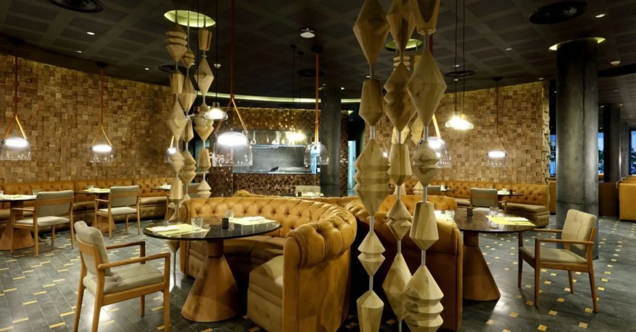 Cozy restaurant interior with leather seating and artistic wood decor in a circular layout.