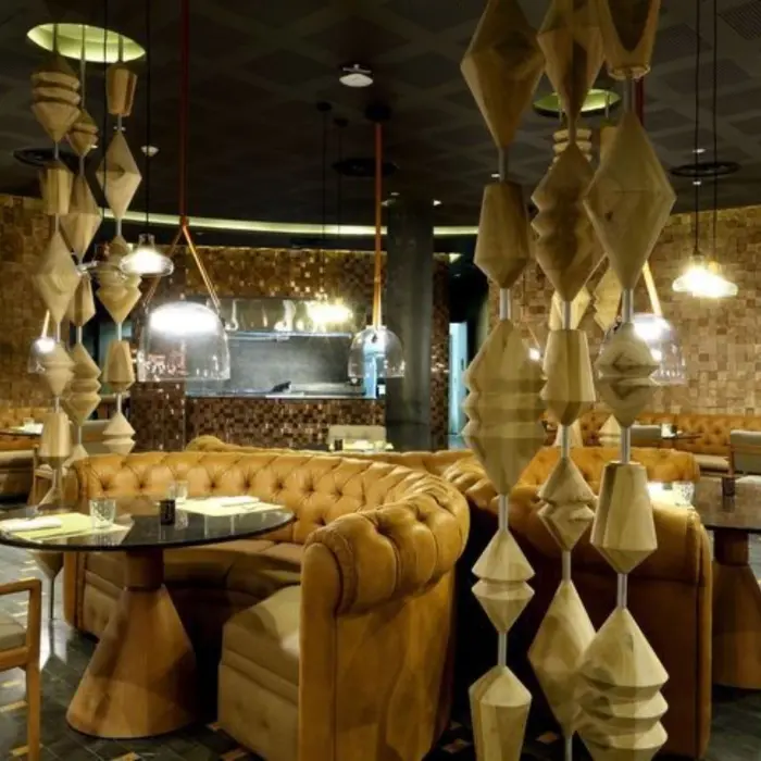 Cozy restaurant interior with leather seating and artistic wood decor in a circular layout.