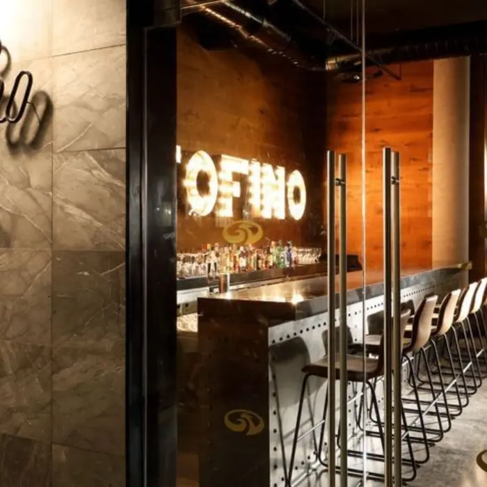 Entrance to Portofino Italian restaurant with stylish signage and sleek bar interior.