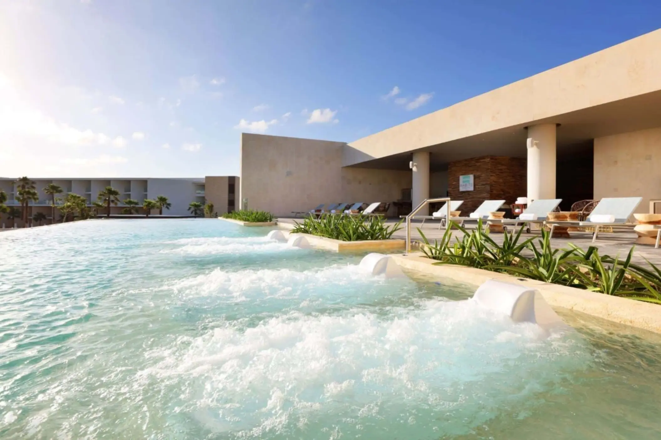 Heated outdoor spa pool area with hydrotherapy jets and modern resort surroundings.