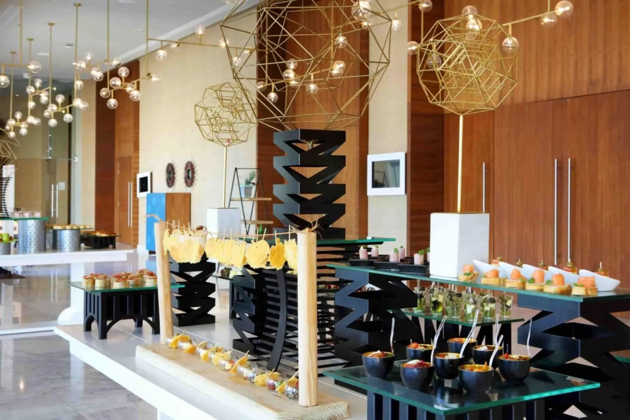 Colorful and artistic buffet setup with modern lighting and geometric decor inside resort dining area.