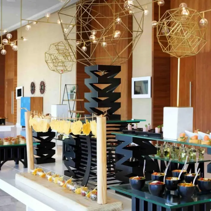 Colorful and artistic buffet setup with modern lighting and geometric decor inside resort dining area.
