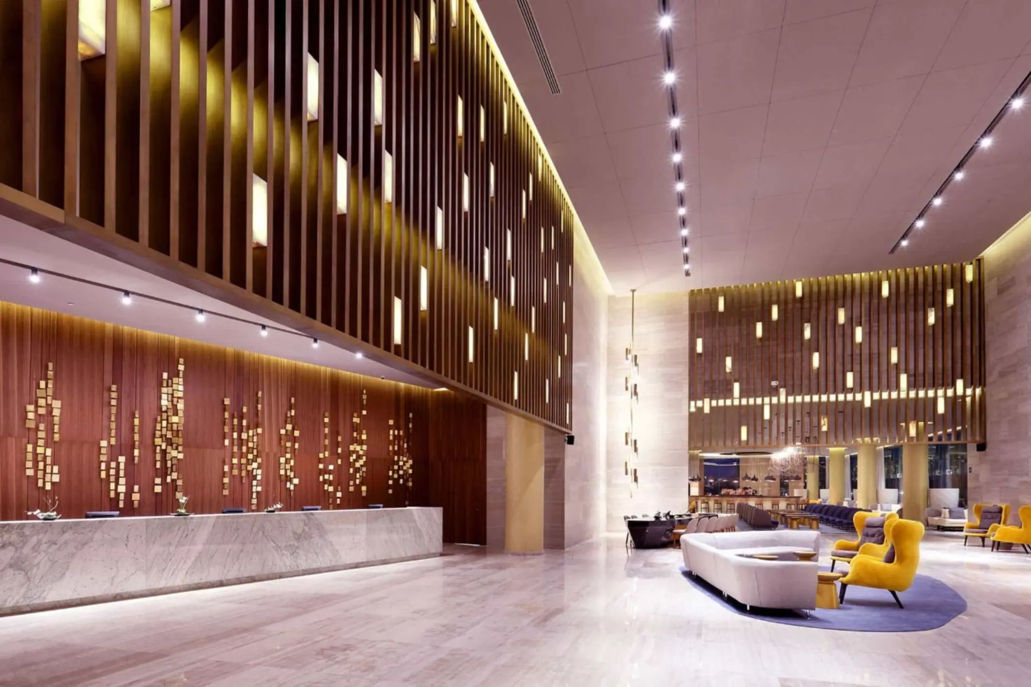 Resort lobby with high ceilings, wood panel accents, and cozy modern seating area.